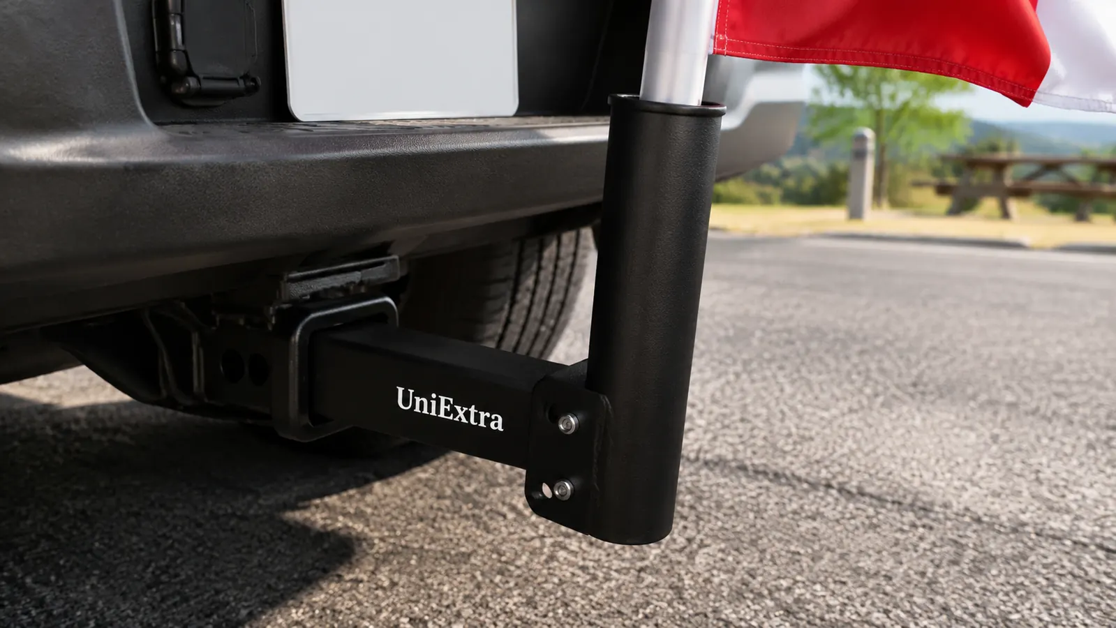 Close-up of a black steel hitch mount flagpole holder with stainless screws inserted into a 2-inch receiver on a truck